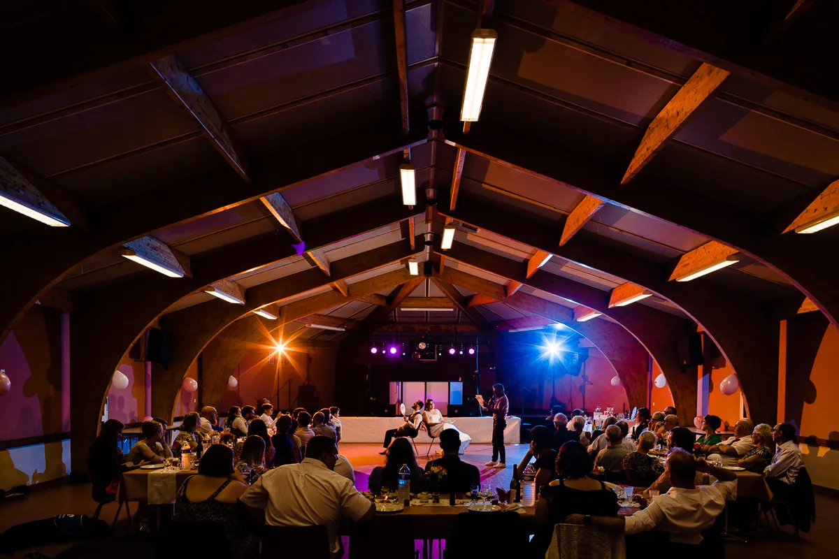Le DJ anime le jeu de lui ou elle en soirée de mariage en salle des fêtes.